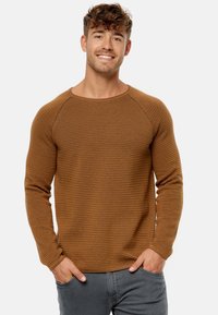 Brun ribbet langærmet sweater med en bred rund hals og raglanærmer, lavet af et struktureret strikstof. Casual pasform.