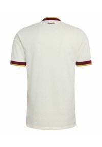 Weißes Trikot mit kurzen Ärmeln und bordeauxrotem sowie gelbem Besatz an Ärmeln und Kragen, mit dem Schriftzug "España" in Bordeaux auf dem oberen Rücken.