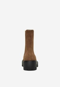 Bottines en cuir suédé marron avec une finition texturée, semelle plateforme noire robuste et détails de couture verticale à l'arrière.