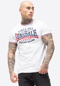 White short-sleeve t-shirt with red and navy blue accents, featuring a graphic logo that reads "Lonsdale London Boxing Brand."