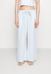 Ljusblå randiga pyjamasbyxor med dragsko i midjan, vida ben och textilstruktur. Har sidfickor för extra bekvämlighet.