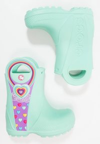 Bottes de pluie en caoutchouc de couleur aqua avec un panneau violet vif orné de cœurs et d'un motif arc-en-ciel, semelles texturées et poignées latérales pour un enfilage facile.