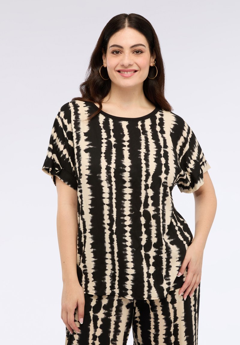 Top de manga corta en tonos negro y beige con un diseño de tie-dye, cuello redondo y bandas horizontales y verticales en una tela suave, con un corte relajado.