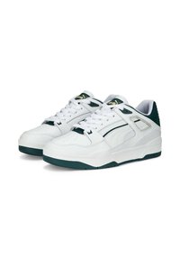 Hvide lædersneakers med grønne accenter, der har en struktureret tåhætte, polstret krave og snøresystem. Ikonisk logo på tungen.