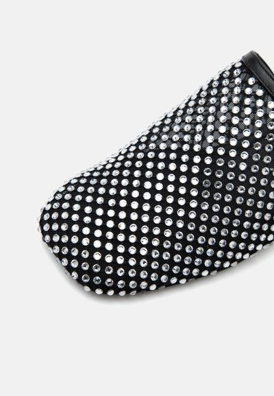Chaussure plate noire couverte de petits strass argentés disposés de façon régulière, montrant les parties avant et latérales.