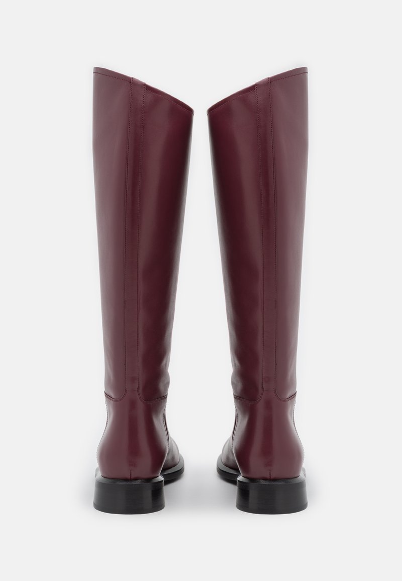 Bordeauxfarbene kniehohe Lederstiefel mit glatter Textur, geradem Design und niedrigem schwarzen Absatz, die dezente Steppnähte an den Seiten aufweisen.