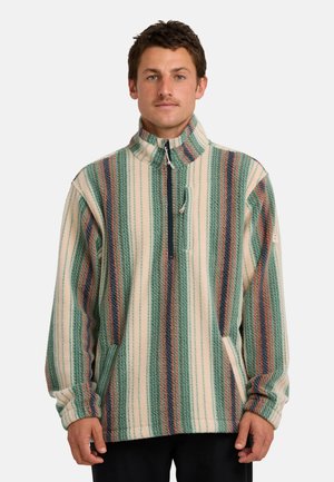 Fleece-Pullover, gestreift in Grün, Creme und Rostfarben. Verfügt über einen hohen Kragen, einen Reißverschluss vorne und seitliche Taschen. Weiches, strukturiertes Material.