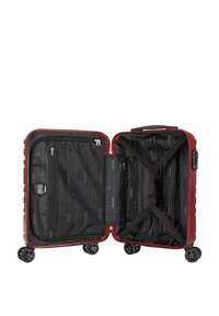 Valise rigide avec un extérieur bordeaux, deux compartiments zippés, un intérieur noir doublé, des sangles croisées et quatre roues pour la mobilité.
