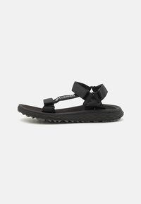 Black outdoor sandal featuring a textured rubber sole, adjustable straps, and a padded footbed for comfort. Minimalist design with functional hardware.