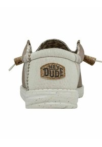 Scarpa slip-on in tela di marrone chiaro e crema con una finitura testurizzata. Presenta un logo "HEY DUDE" e una suola ecologica maculata.