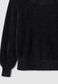 Czarny puszysty sweter z długimi balonowymi rękawami oraz prążkowanymi mankietami i dołem na jasnym tle.