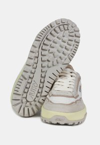 Beige en crèmekleurige sneakers met een gestructureerde stoffen bovenkant en suède accenten. Dikke rubberen zool met een zigzagprofiel en merklogo.