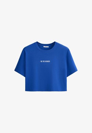 Kék rövidített póló rövid ujjakkal, elöl középen fehér felirattal: "I'M THE WINNER", egyszerű fehér háttér előtt.