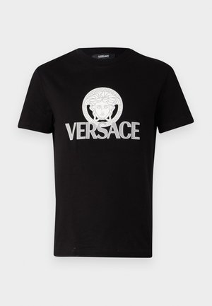 Camiseta de algodón negra con un gráfico impreso de Medusa en blanco y el texto "VERSACE" en letras gruesas en el pecho. Diseño de cuello redondo.