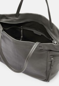 Borsa tote grigia in pelle con una texture liscia, dotata di una tasca interna con zip e due manici robusti. Design minimalista senza decorazioni.