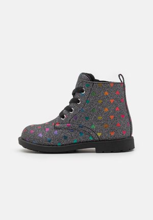 Bottines noires avec finition pailletée, ornées de motifs colorés en forme de cœur, dotées de lacets ronds, d'œillets et d'une semelle en caoutchouc texturée.