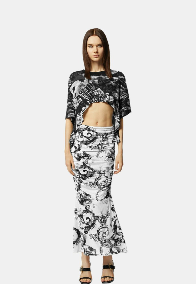 Schwarzes und weißes, tailliertes Oberteil mit grafischem Text, kombiniert mit einem langen, figurbetonten Rock, der sich durch wirbelnde Muster in Schwarz auf einem weißen Hintergrund auszeichnet.