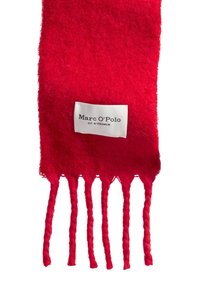Écharpe en laine rouge avec des détails en franges, portant une étiquette blanche avec le texte « Marc O'Polo » et « EST. IN STOCKHOLM » à une extrémité.