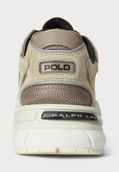 Bežs un brūns sporta apavu papēdis ar strukturētu audumu, zamšādas akcentiem, "POLO" uzlīme augšpusē un "RALPH LAUREN" uz baltās zoles.