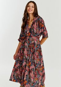 Kwiatowa sukienka z lekkiego materiału, z głębokim dekoltem w kształcie litery V, krótkimi bufkami i dopasowaną talią, z długością do kolan, zwiewnym dołem.