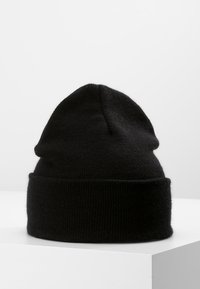 Cappello a beanie nero lavorato a maglia con una texture morbida, caratterizzato da un risvolto e una parte superiore tonda. Design semplice, senza motivi o accenti aggiuntivi.