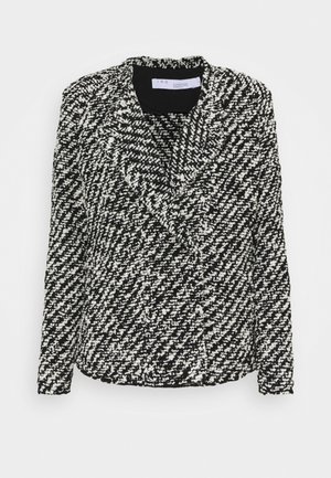 Blazer bouclé texturé noir et blanc avec manches longues et col à revers cranté, plié à plat sur fond blanc.