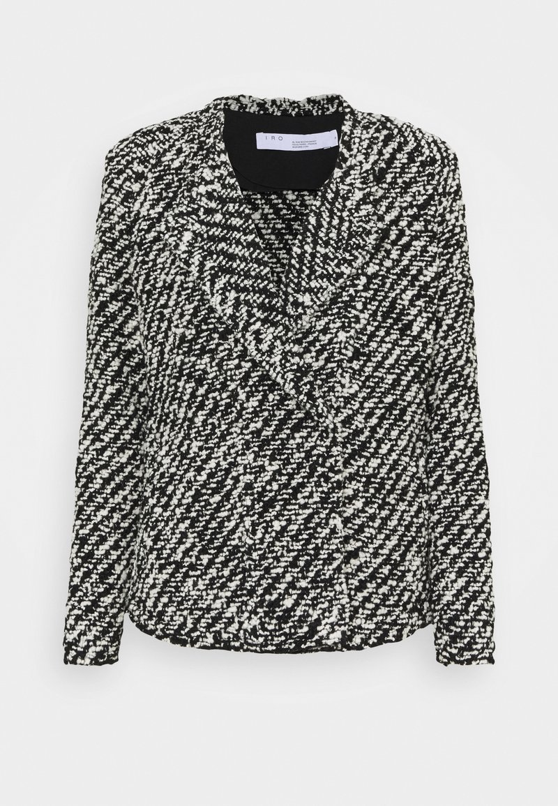 Blazer bouclé texturé noir et blanc avec manches longues et col à revers cranté, plié à plat sur fond blanc.