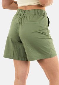 Pantaloni corti verdi con una cintura elastica, texture morbida, due tasche posteriori e un taglio dritto all'altezza del medio coscia.