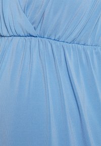 Tecido azul claro com uma textura suave e macia, apresentando detalhes franzidos e pregas suaves. O design inclui uma cintura para definição da forma.