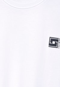 T-shirt bianca in cotone con un logo rettangolare nero con testo, scollo rotondo e maniche corte. Texture liscia, senza motivi.