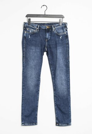 Pantalones vaqueros azules de mezclilla con un ligero desgaste en los bolsillos, colgados en una percha de plástico negra contra un fondo blanco.