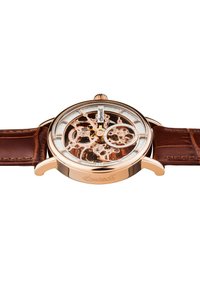 Orologio meccanico con cassa in oro rosa, cinturino in pelle marrone, quadrante aperto che mostra ingranaggi intricati, accenti argentati e una corona decorativa.