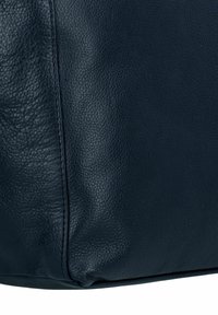 Borsa in pelle blu scuro con una texture a granuli e cuciture visibili lungo le cuciture. Forma arrotondata con bordi morbidi.