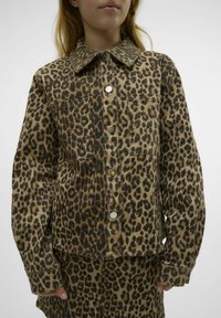 Denim jakna z leopardjim vzorcem, s ovratnikom, sprednjimi žepi in kovinskimi pritisnimi gumbi. Ima sproščen kroj in teksturirano tkanino.