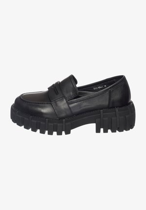 Les mocassins en cuir noir sont dotés d'un bout arrondi et de coutures prononcées, avec une épaisse semelle en caoutchouc noir robuste et sans attaches visibles.