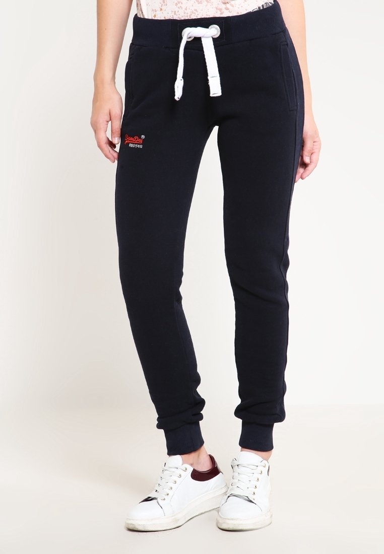 Marinblå joggers med dragsko i midjan och vita detaljer, med två sidofickor och ett mjukt, texturerat tyg.