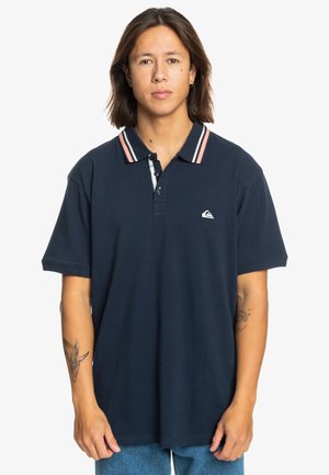 Marineblauwe polo-shirt van katoen met een klassieke kraag met roze en witte strepen, logodetail op de borst en korte mouwen.
