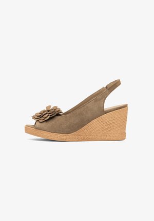 Brązowy zamszowy sandał na koturnie z kwiatową ozdobą z przodu oraz plecioną teksturą na platformie i obcasie, z odkrytym noskiem i paskiem wokół pięty.