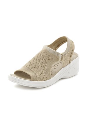 Beige offene, gestrickte Sandale mit Zehenöffnung, strukturiertem Obermaterial, elastischem Rückriemen und weißer, gepolsterter Keilsohle, schräg gestellt, um Seiten- und Vorderansicht zu zeigen.