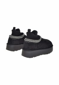 Stivali alla caviglia in suede nero con un colletto in maglia testurizzata, dotati di un bordo decorativo cucito e di una suola in gomma nera con un leggero plateau.