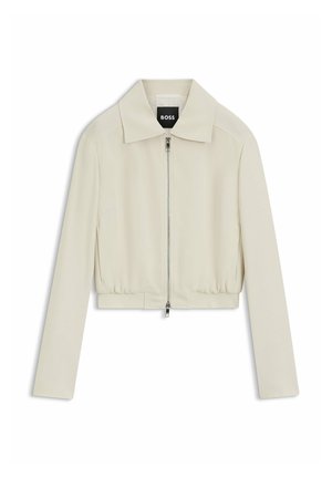 Veste beige clair zippée avec col pointu, manches longues et taille élastique, estampillée avec l’étiquette "BOSS" à l’intérieur du col.