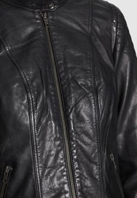 Black leather jacket with a smooth texture, zip closure, and prominent seam details. Features two side pockets and a snap collar.