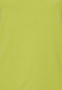 Vibrante tessuto di cotone verde lime con una texture liscia, caratterizzato da un colore uniforme senza motivi né decorazioni.