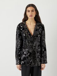 Blazer en velours noir orné de sequins floraux argentés, avec un décolleté en V profond, trois boutons et deux poches avant.