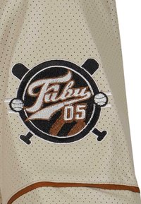 Maglione color crema con texture perforata presenta un logo ricamato con elementi sportivi, accenti marroni e il numero "05."
