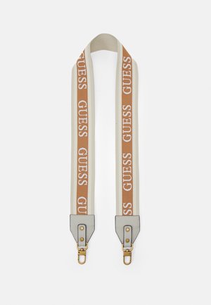 Bandoulière réglable en tissu beige et marron avec le texte "GUESS" et des fermoirs métalliques dorés sur des extrémités en cuir gris clair.