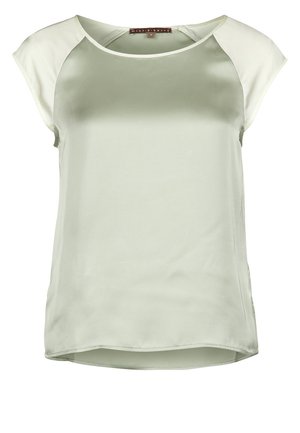 Satynowa zielona bluzka z krótkimi kremowymi rękawami raglanowymi, okrągłym dekoltem i lekko zaokrąglonym dołem. Gładka faktura i swobodny design.