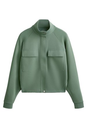 Green cropped jacket made of a soft, textured material. Features a high collar, two chest pockets, and snap closure at the front.