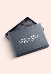 Graue, strukturierte Schmuckschatulle mit offenem Deckel, der schwarzes Seidenpapier im Inneren zeigt. "Sofia Milani Jewels" ist in Weiß auf dem Deckel aufgedruckt.