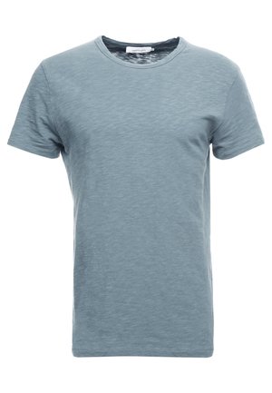T-shirt uni bleu clair à manches courtes avec col rond, texture subtile et bande de col étroite.